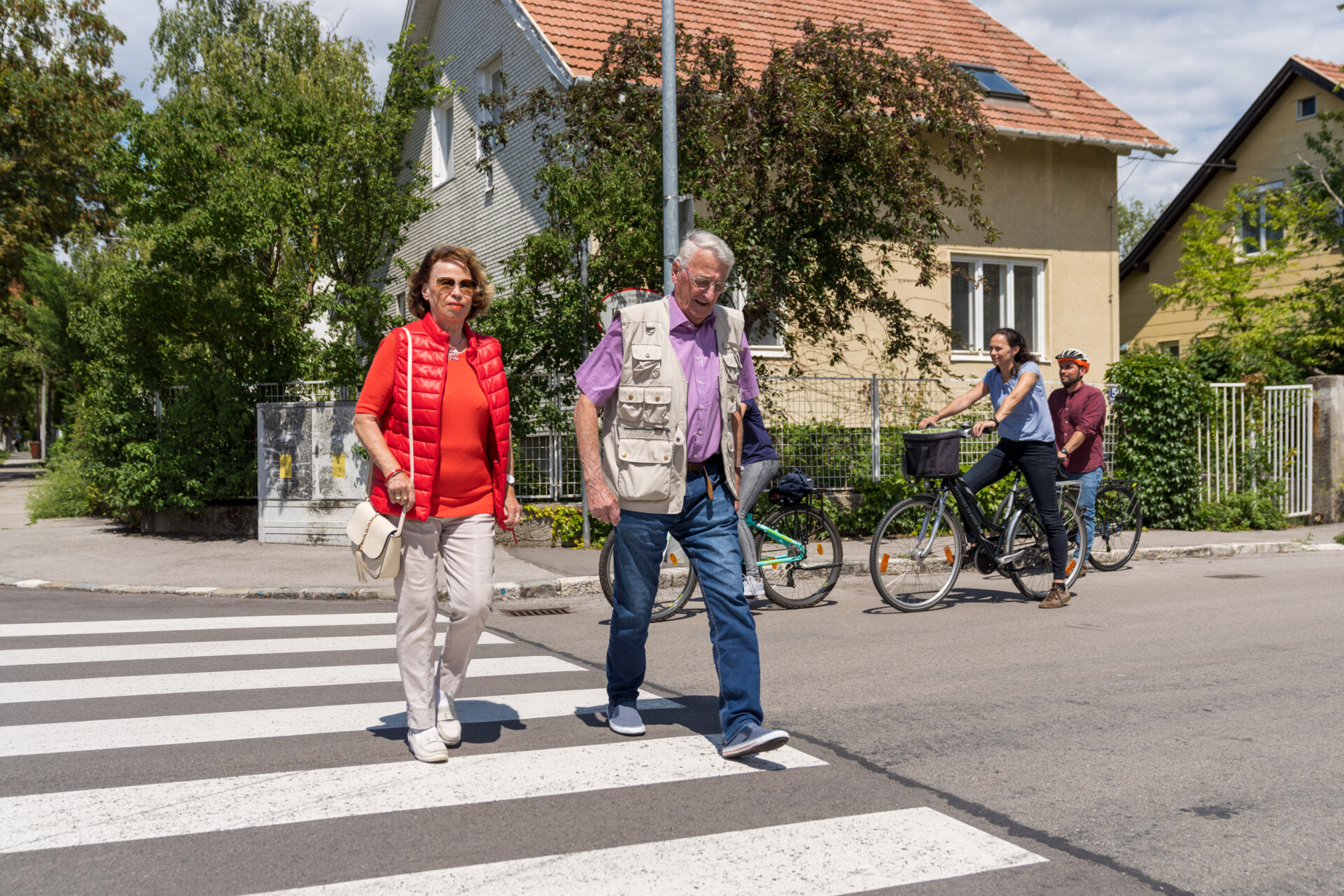 Zwei ältere Personen gehen über Schutzweg