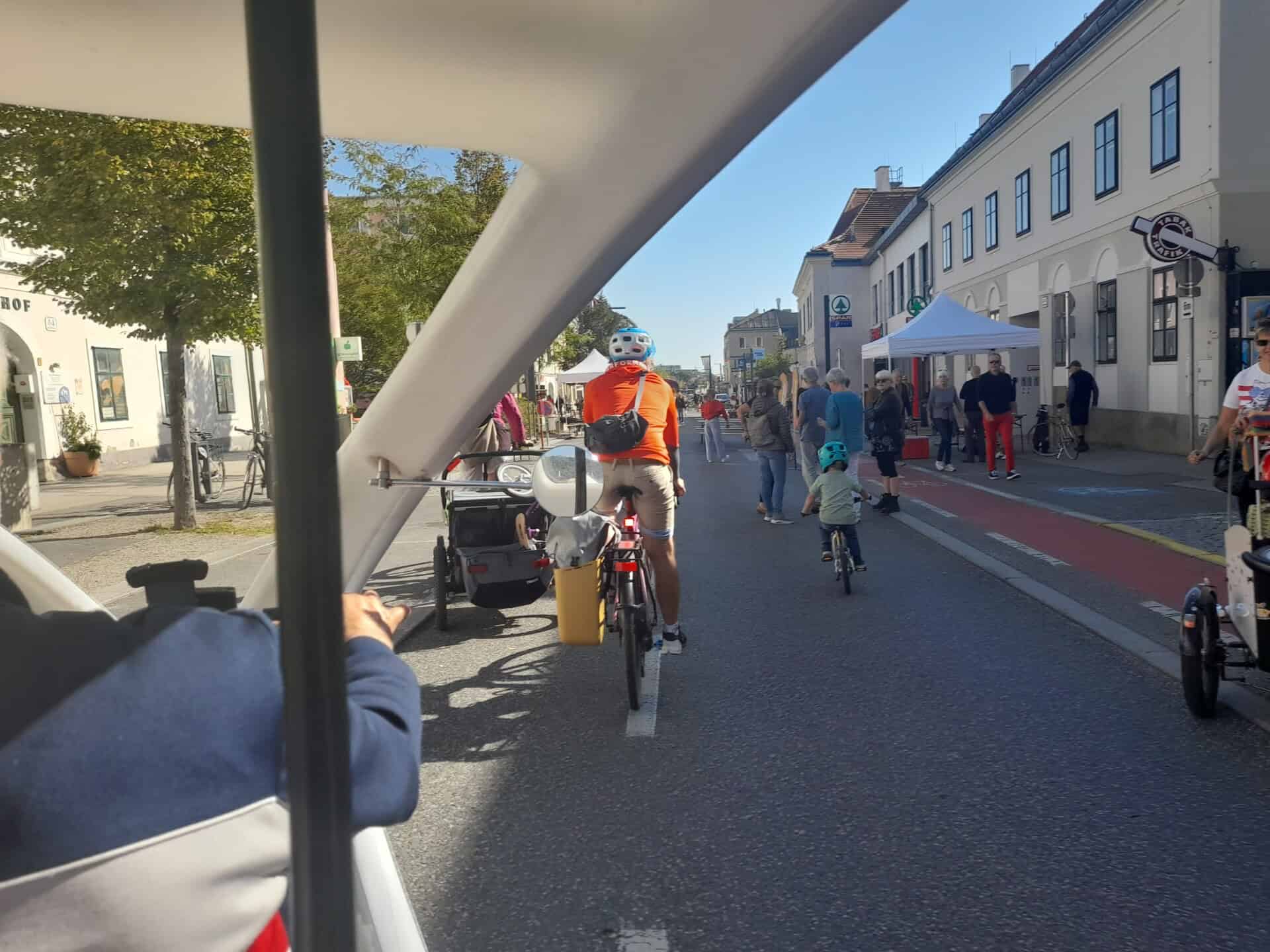 Blick vom Fahrradtaxi auf die gesperrte, belebte Hauptstraße