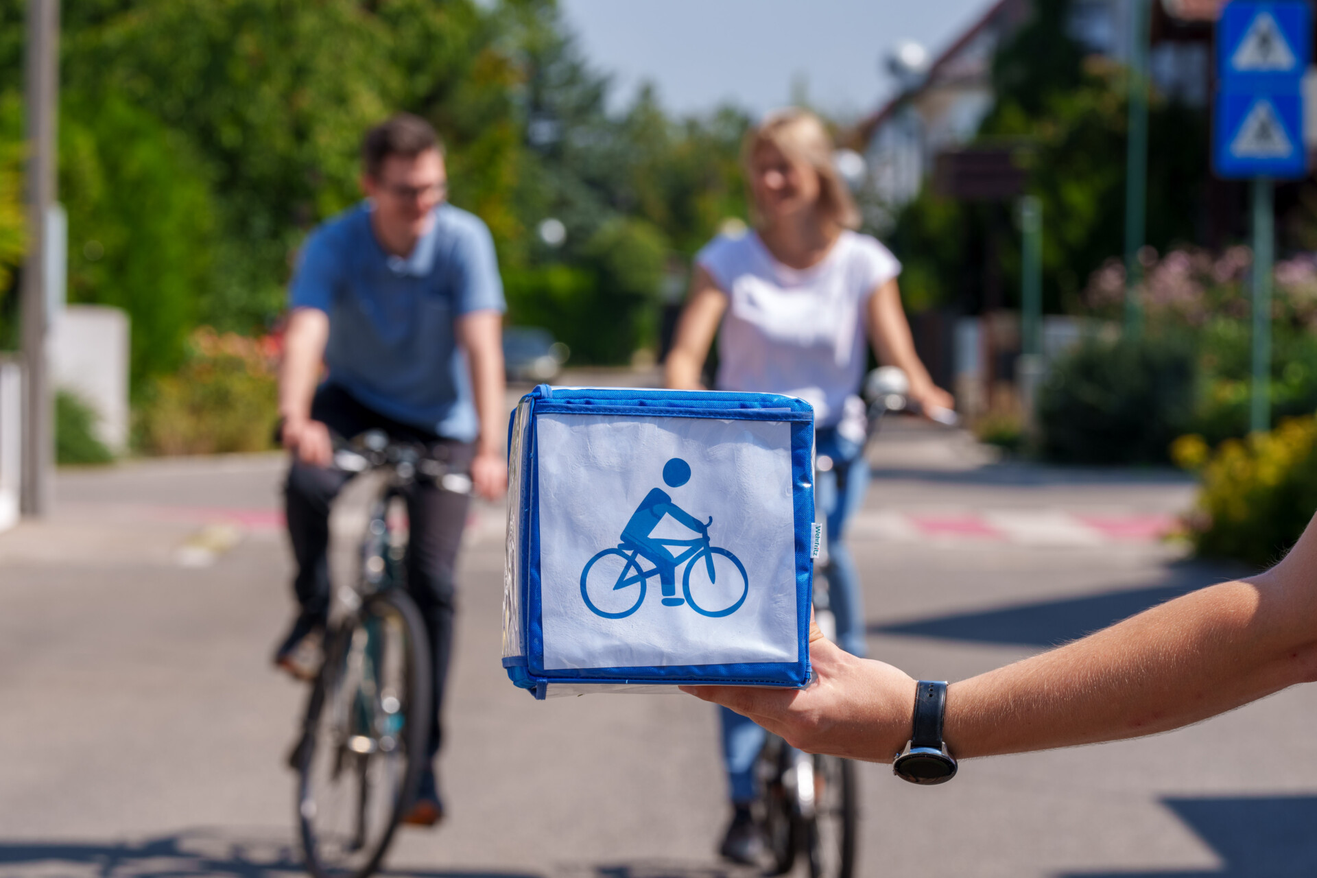 Im Vordergrund Symbol mit Fahrrad, im Hintergrund Radfahrende