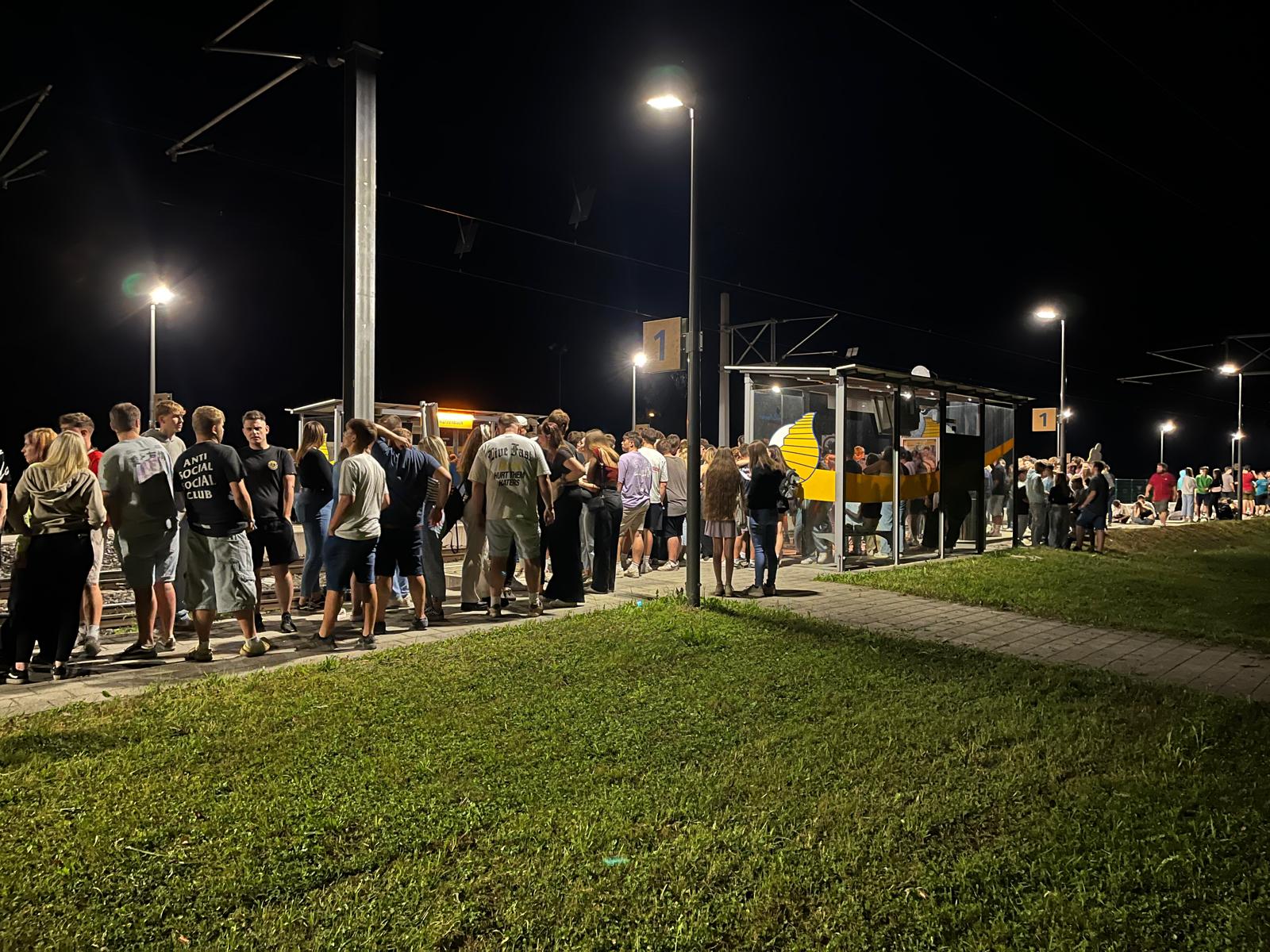 Viele Jugendliche warten in der Nacht am Bahnsteig auf den Zug