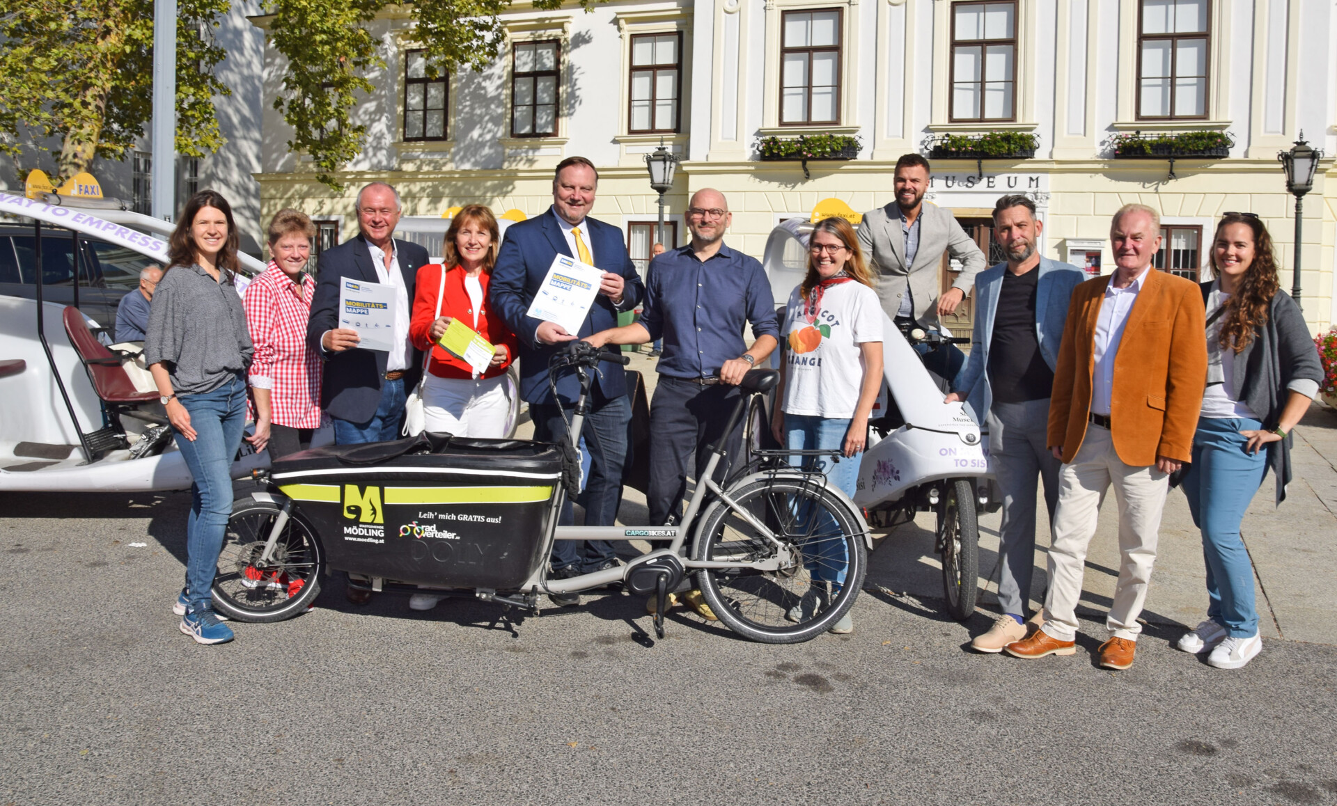 Gruppe mit LAstenrad , Mobilitätsmappe und Gehzeit.Karte in den Händen