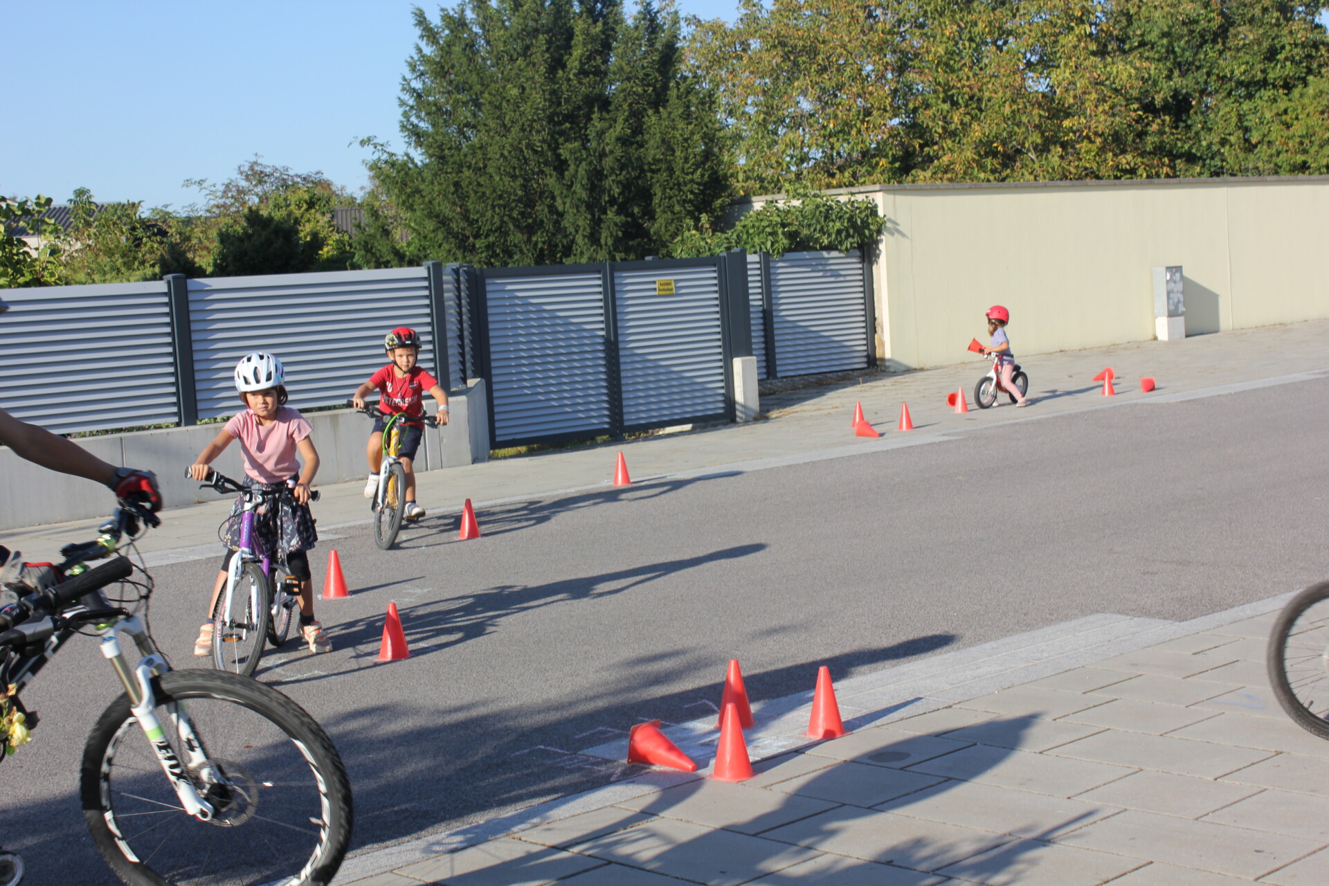 Kinder fahren einen Radparcours mit  Verkehrshütchen