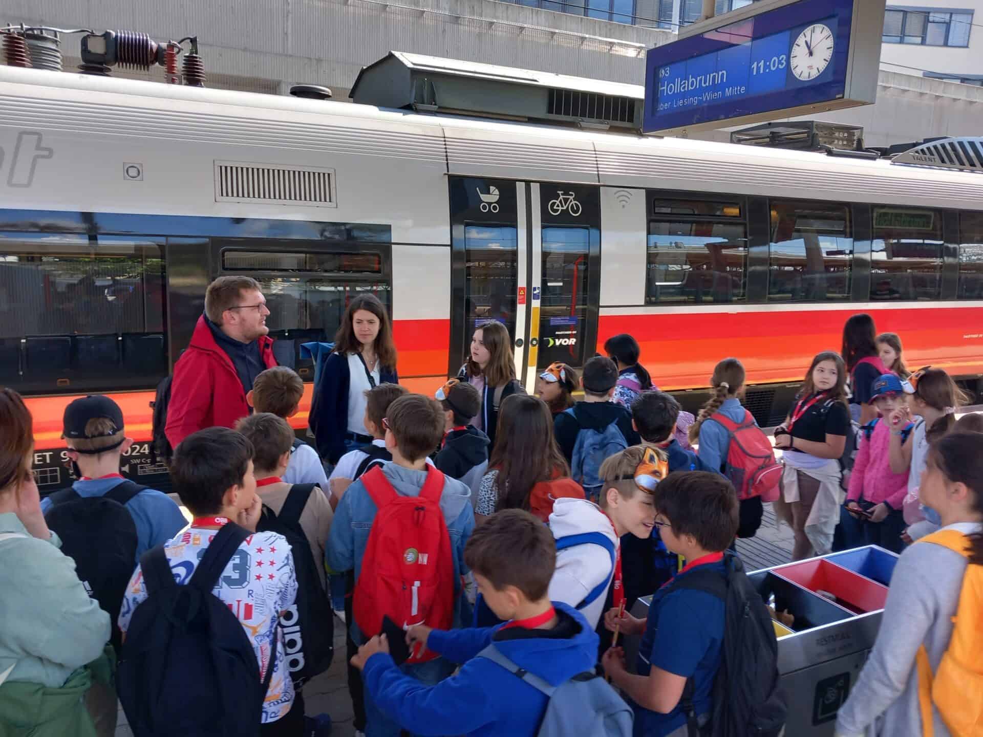 Kinder auf dem Bahnsteig mit Zug im Hintergrund