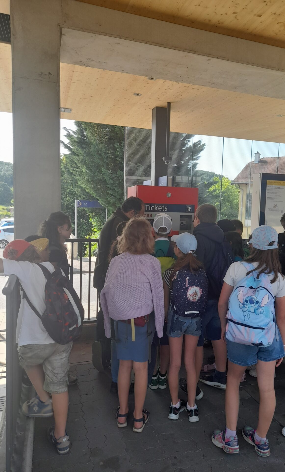 Kinder vor einem Ticketautomaten am Bahnhof
