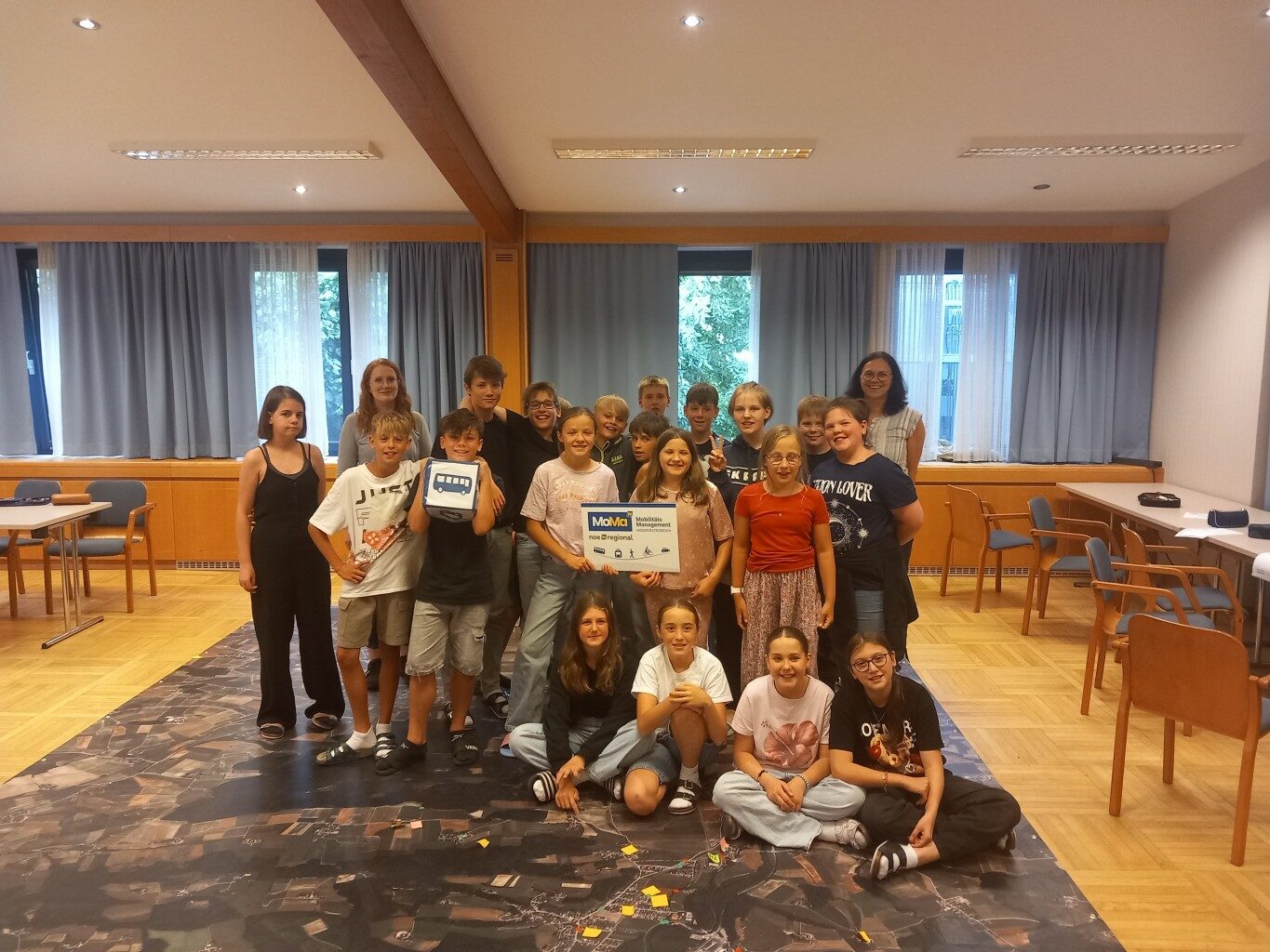 Eine Schulklasse steht auf einem großen Luftbild
