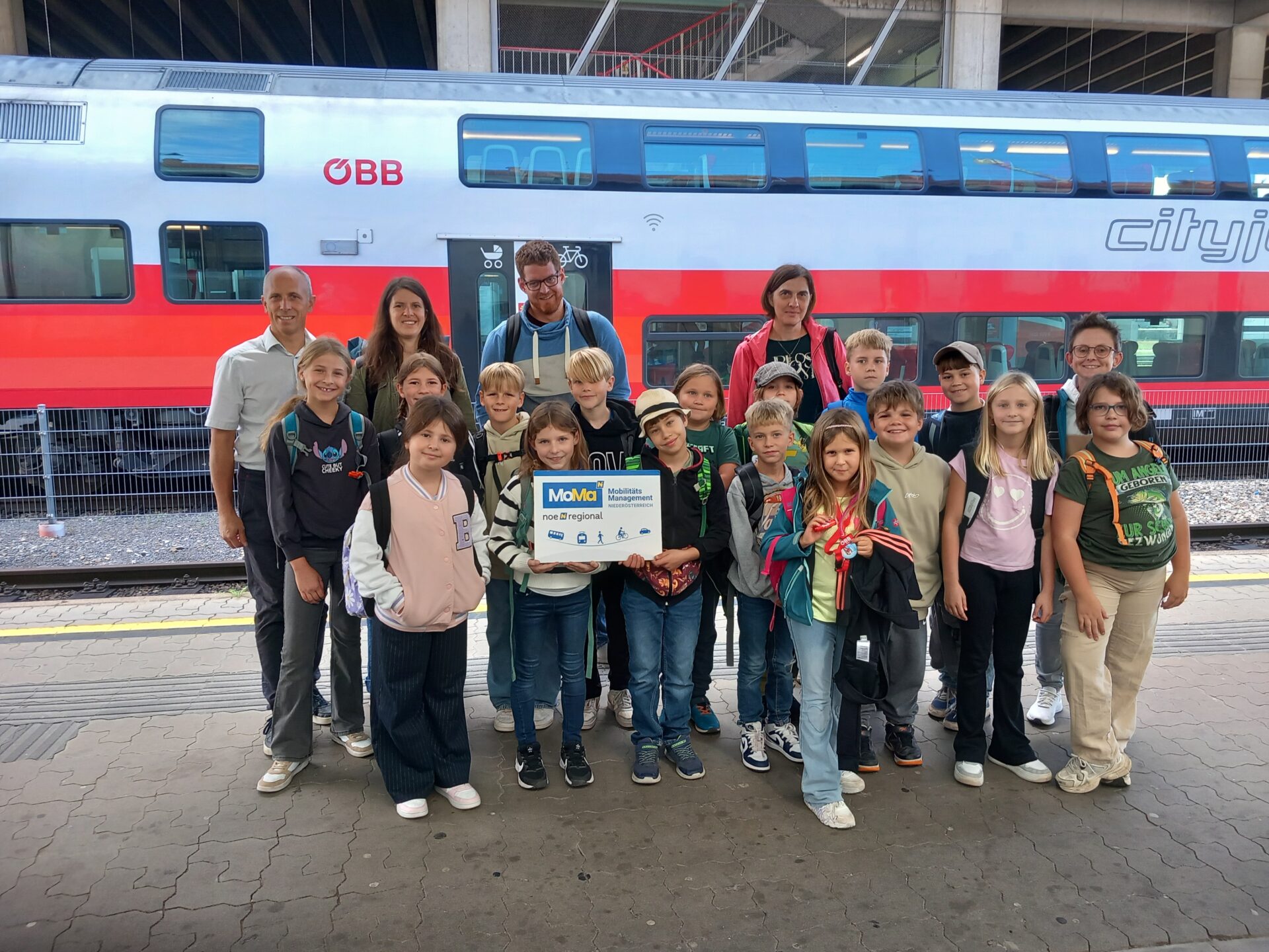 Kinder und Erwachsene stehen vor Zug am Bahnhof Krems an der Donau