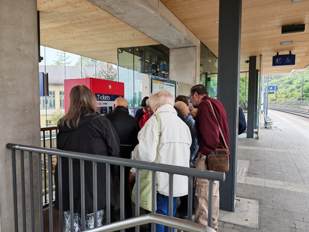 Senior Mobil Berater übt mit Teilnehmerinnen und Teilnehmern am ÖBB Ticketautomaten