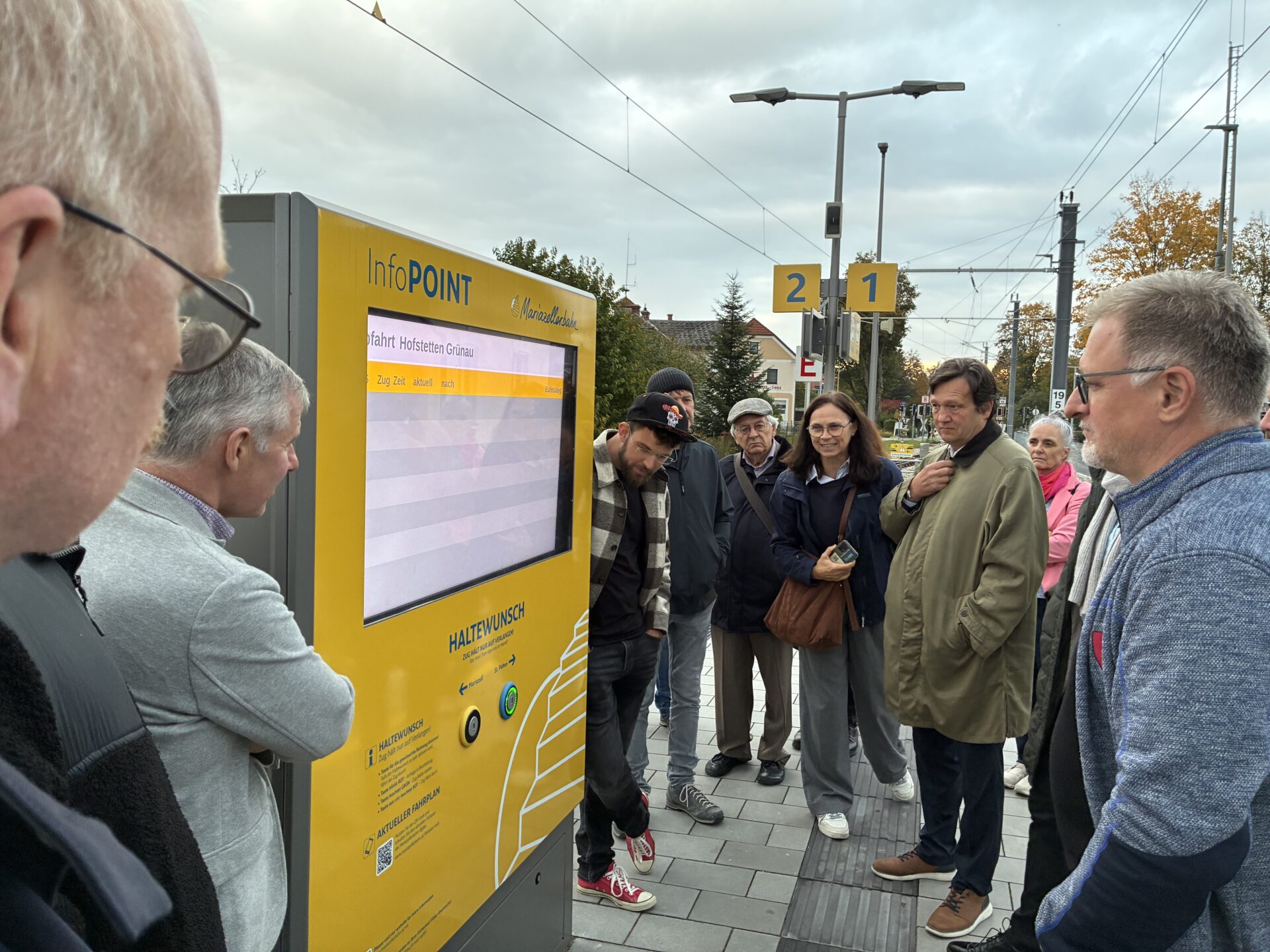 Menschen schauen Anzeigetafel am Bahnhof an